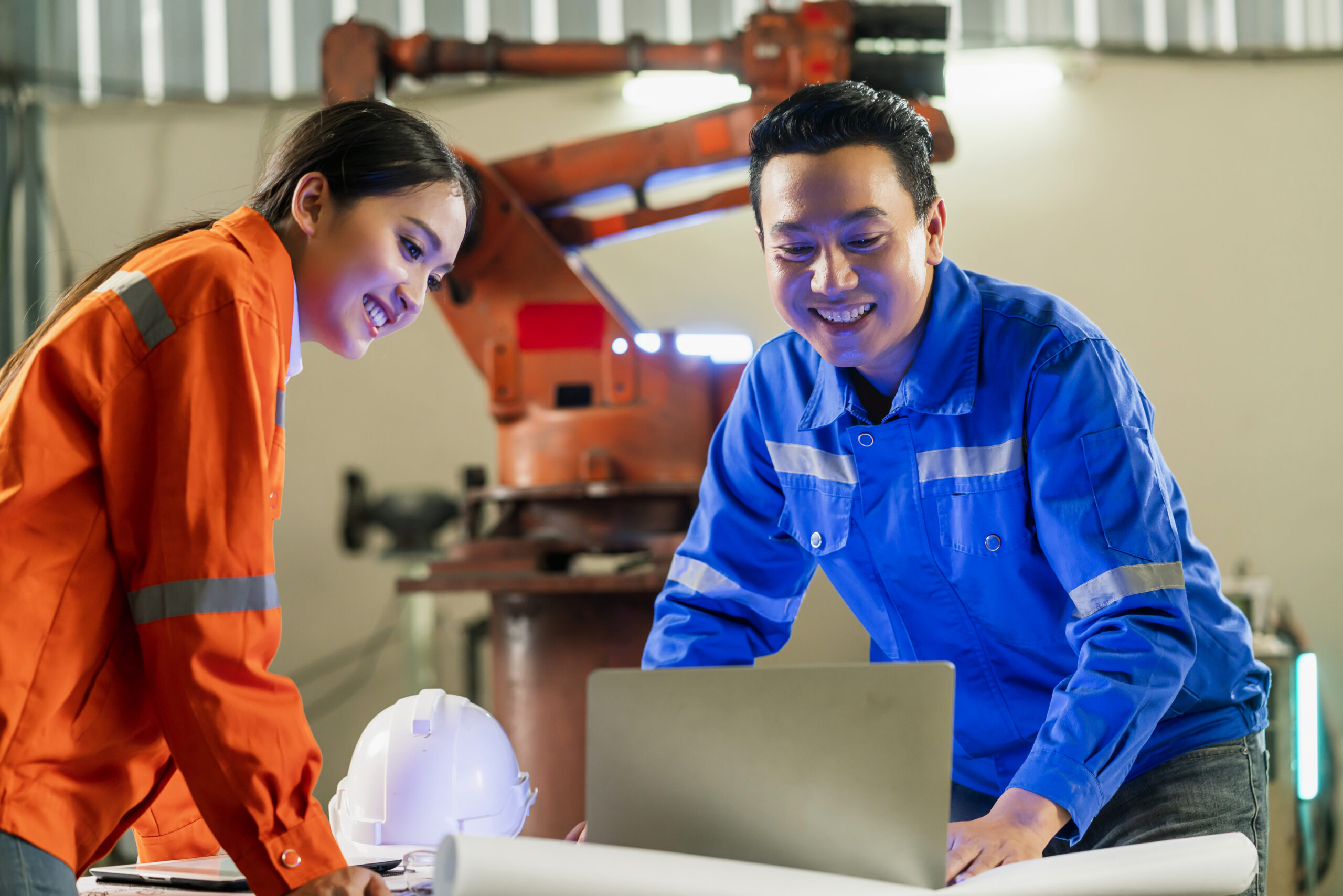 bps engineer (2) engineer cooperation Two asian male and female technician maintenance inspect relay robot system with tablet laptop to control quality operate process work heavy industry 4.0 manufacturing factory